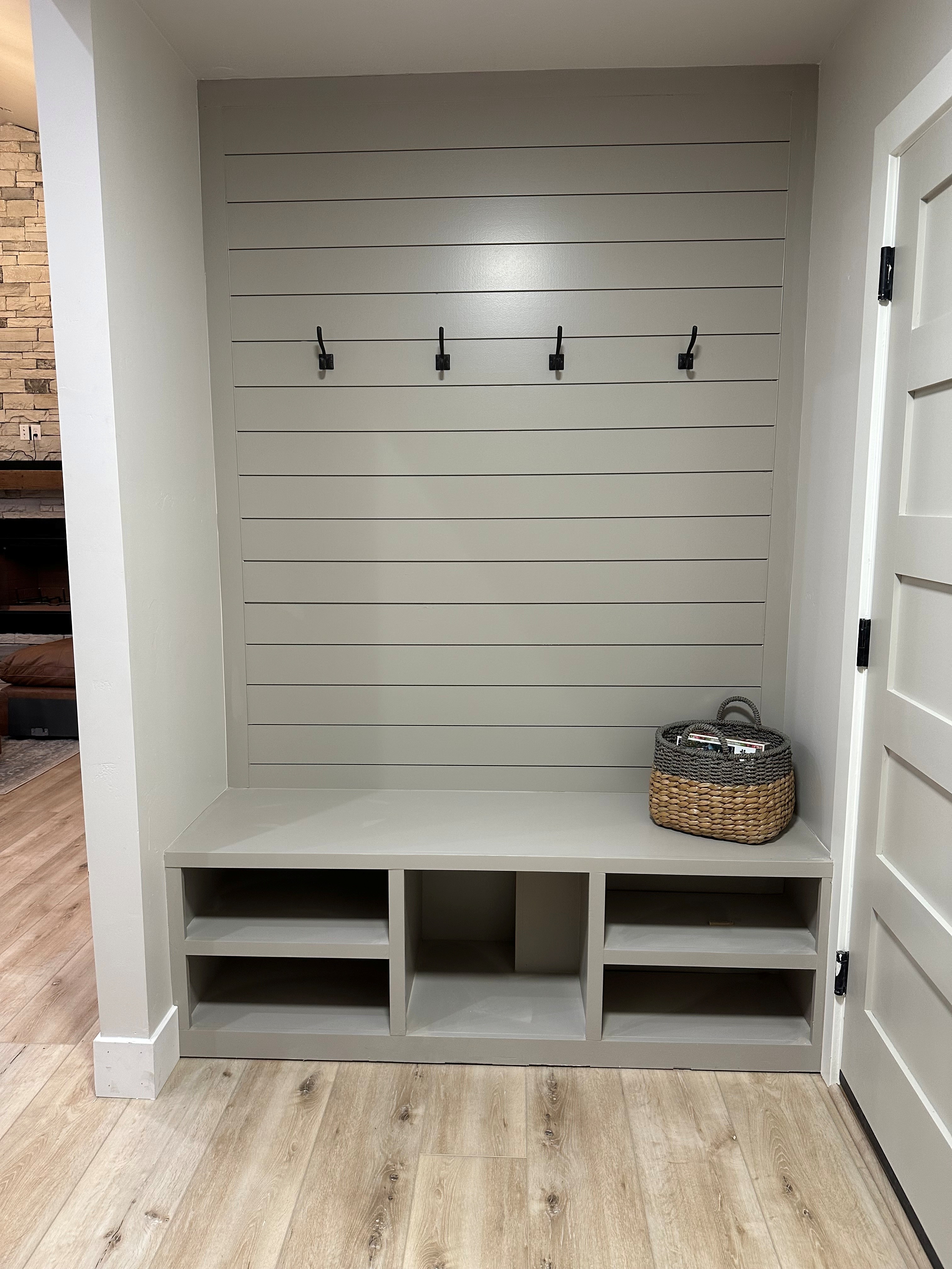 Laundry and mudroom storage with hooks, bench, and cubbies